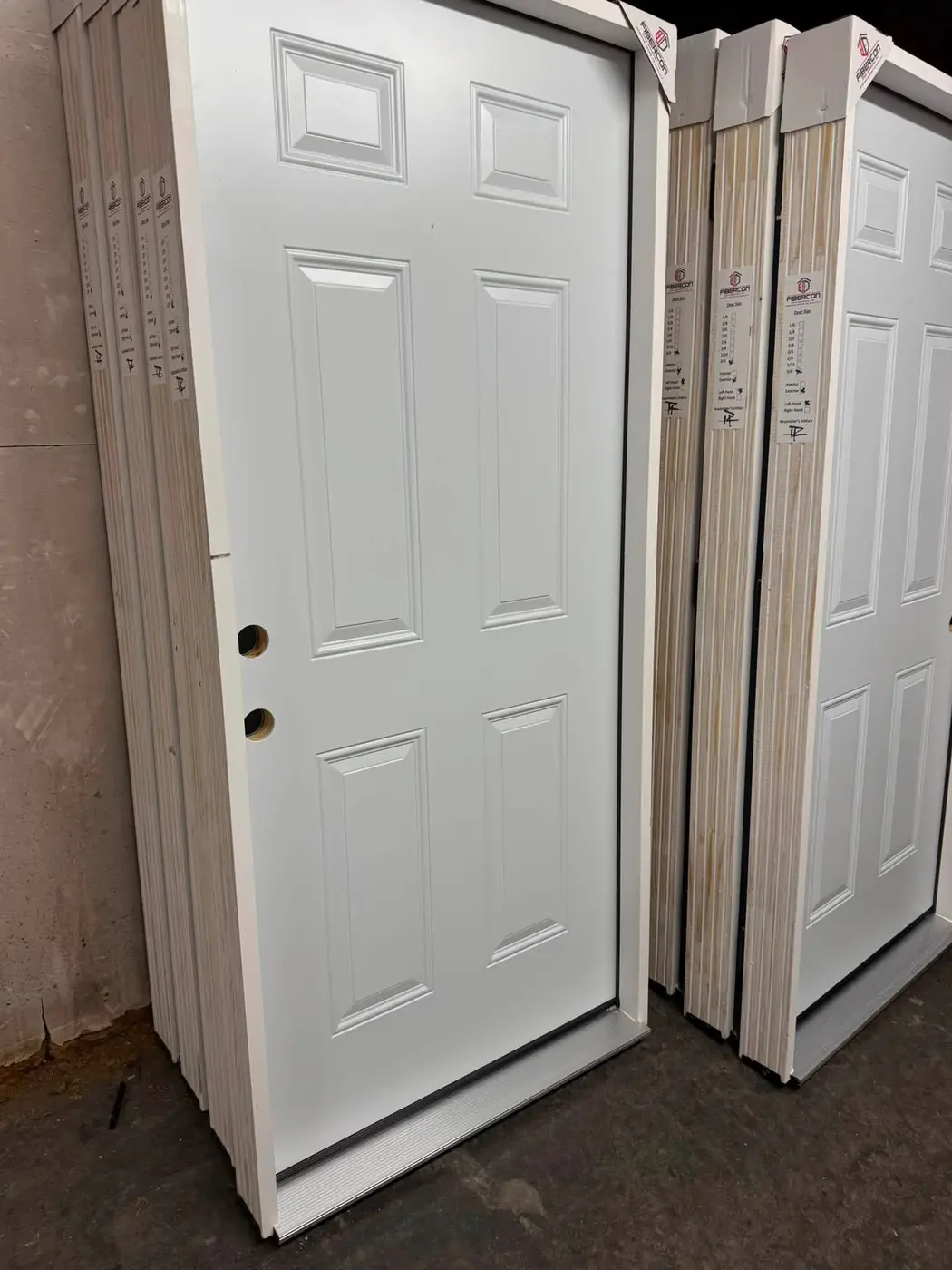 Classic white six-panel entry doors in warehouse stock