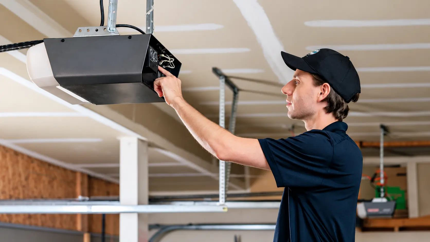 Technician checking an overhead garage door opener motor
