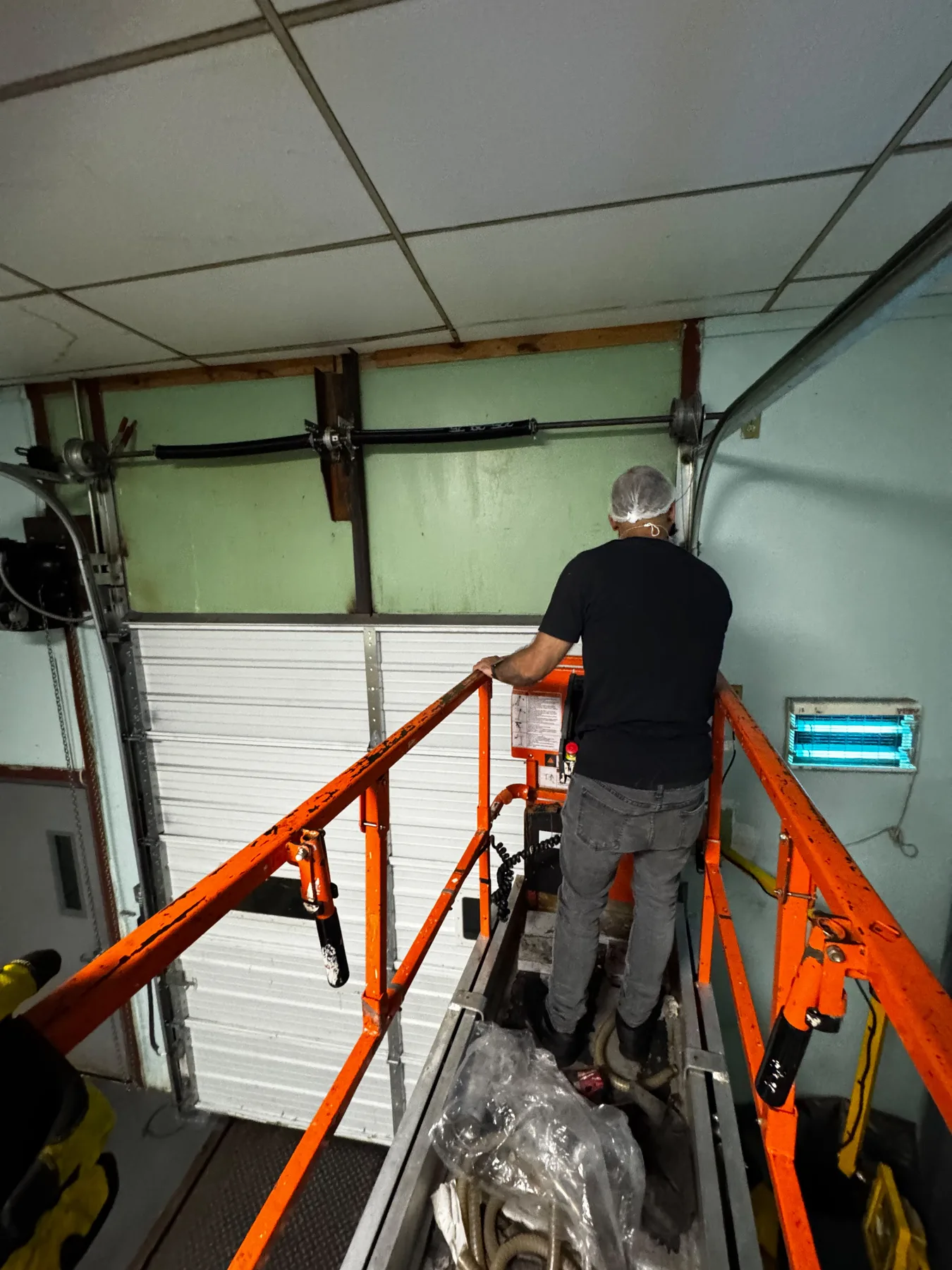 Garage door technician on lift